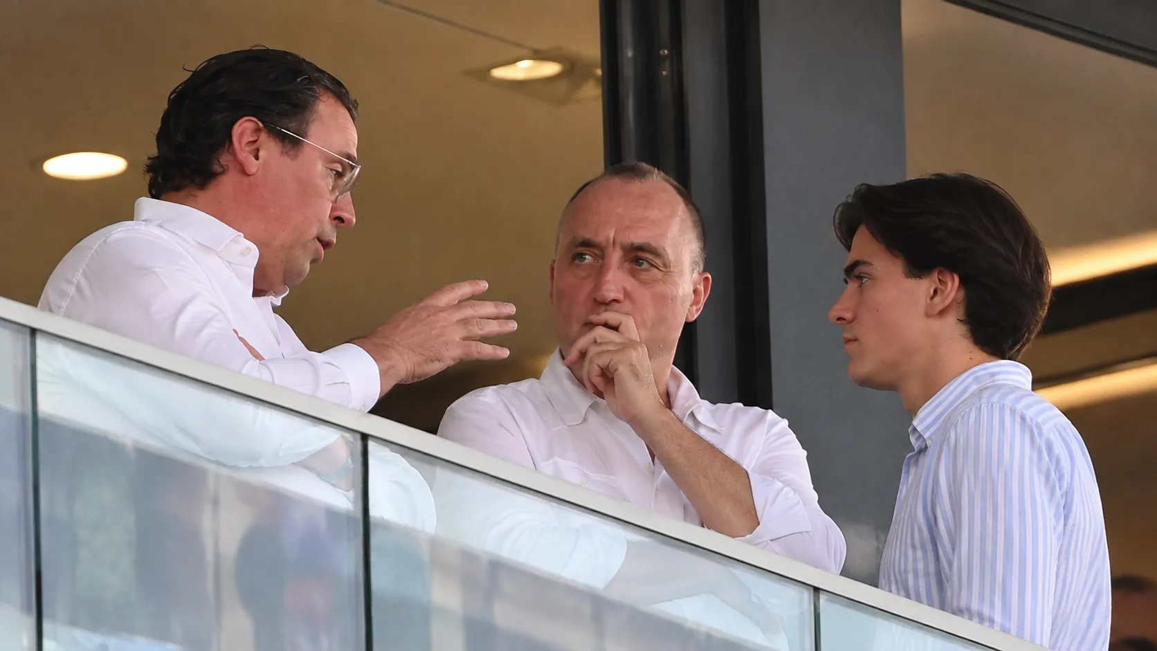 Niet-spelende clubvertegenwoordigers overleggen in een stadionbox.