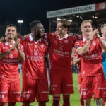Een groep spelers van KV Kortrijk viert samen op het veld na een wedstrijd.