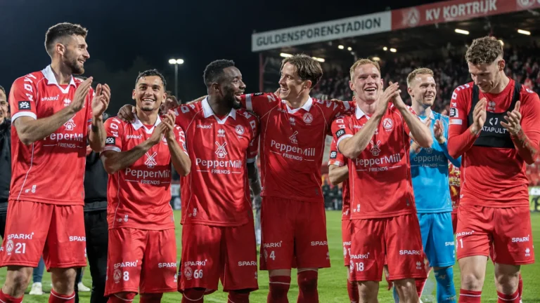 Een groep spelers van KV Kortrijk viert samen op het veld na een wedstrijd.