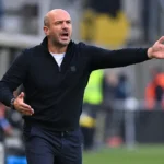 Frédéric De Meyer geeft aanwijzingen langs de zijlijn tijdens een voetbalwedstrijd.