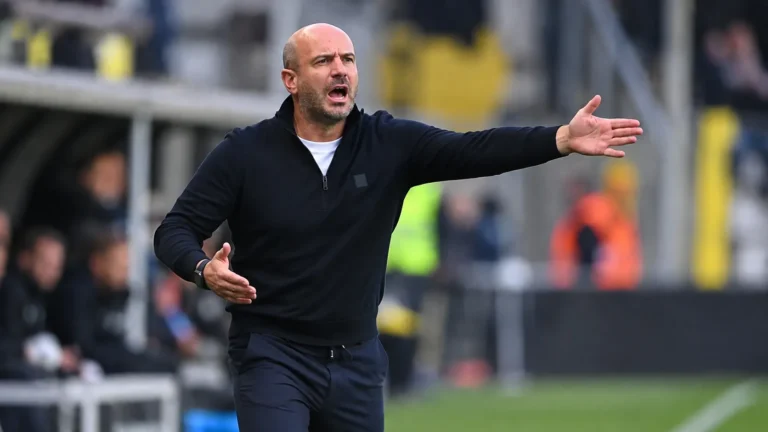 Frédéric De Meyer geeft aanwijzingen langs de zijlijn tijdens een voetbalwedstrijd.
