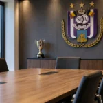 Lege vergaderruimte van RSC Anderlecht met een clubembleem aan de wand.