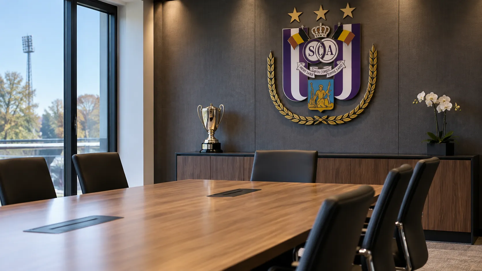 Lege vergaderruimte van RSC Anderlecht met een clubembleem aan de wand.