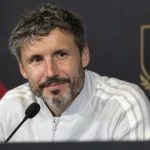 Mark van Bommel aan een persconferentietafel met een Belgisch nationaal ploegembleem op de achtergrond.