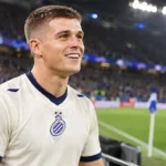 Nicolo Tresoldi van Club Brugge staat ontspannen aan de rand van het veld.