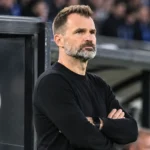 Ivan Leko observeert het veld vanaf de zijlijn, met een Club Brugge-embleem op de dug-out.