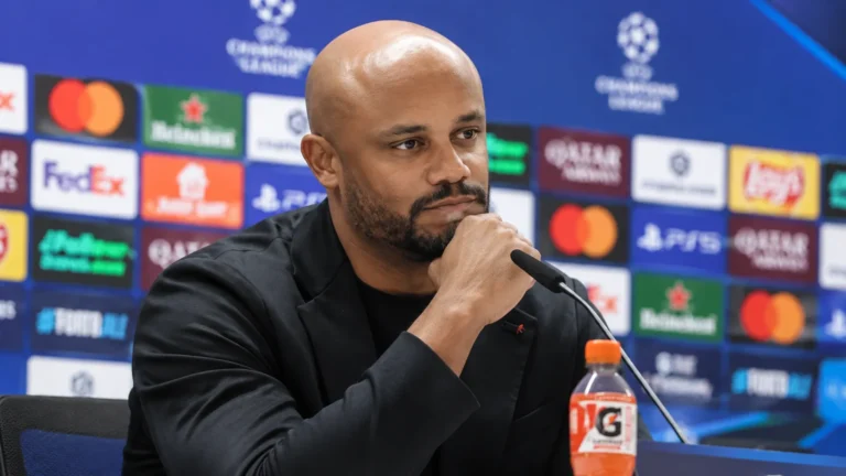 Vincent Kompany spreekt op een persconferentie achter een microfoon.