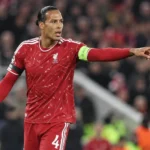 Virgil van Dijk in Liverpool-tenue met de aanvoerdersband tijdens een wedstrijd.