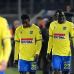 Westerlo-spelers wandelen samen langs de zijlijn na een wedstrijd.