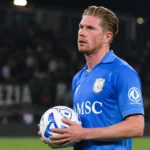 Kevin De Bruyne van Napoli kijkt geconcentreerd op het veld terwijl hij een bal vasthoudt.