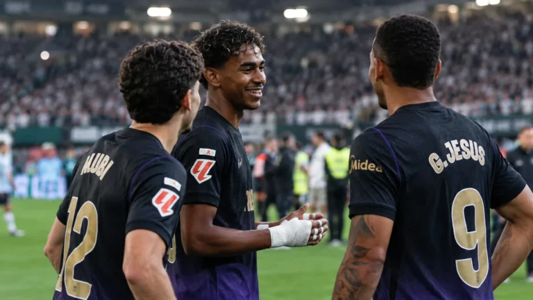 Lamine Yamal staat na de wedstrijd met twee ploegmaats op het veld in donkere wedstrijdshirts.