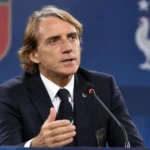 Roberto Mancini spreekt in een persconferentiezaal in zijn donkere Italiaanse bondscoachpak.
