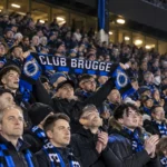 Collectieve Club Brugge-supporters met blauw-zwarte sjaals in het stadion.