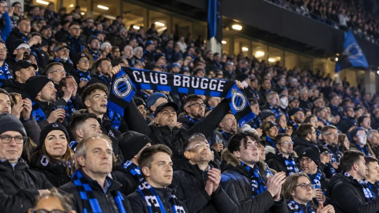 Collectieve Club Brugge-supporters met blauw-zwarte sjaals in het stadion.