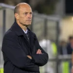 Jess Thorup in donkere jas langs de zijlijn na een bekerwedstrijd van KRC Genk.