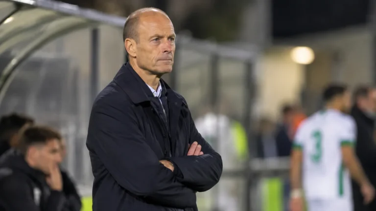 Jess Thorup in donkere jas langs de zijlijn na een bekerwedstrijd van KRC Genk.