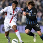 Twee voetballers van Antwerp en Club Brugge in een duel om de bal.