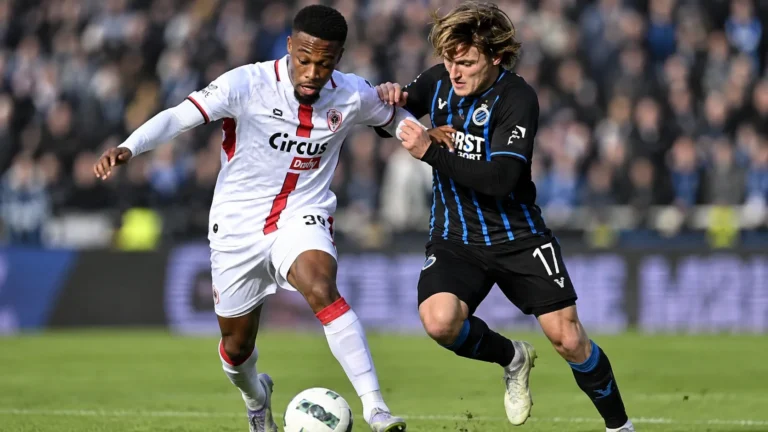 Twee voetballers van Antwerp en Club Brugge in een duel om de bal.