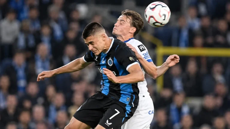 Twee voetballers vechten een luchtduel uit tijdens een wedstrijd.