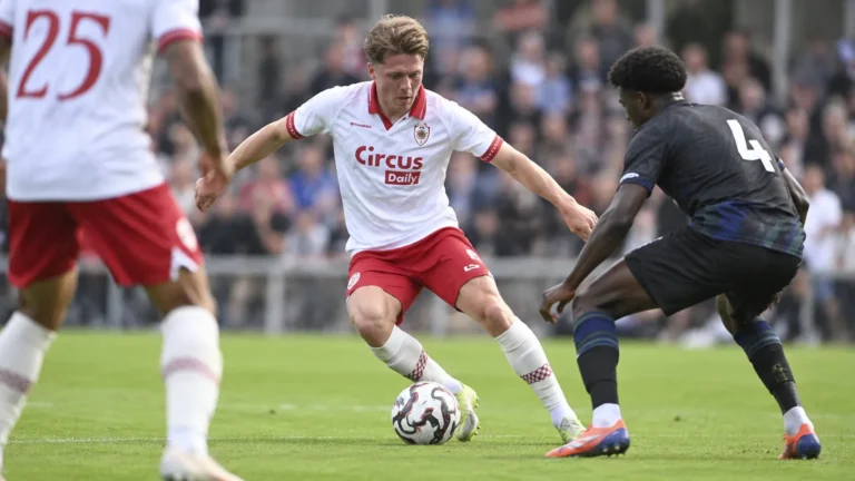 Rein Van Helden van Antwerp in actie met de bal in een wit-rood wedstrijdtenue.