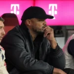 Vincent Kompany zit op de reservebank tijdens een voetbalwedstrijd.