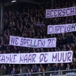 Beerschot-supporters op ’t Kiel met grote witte spandoeken en paarse belettering.