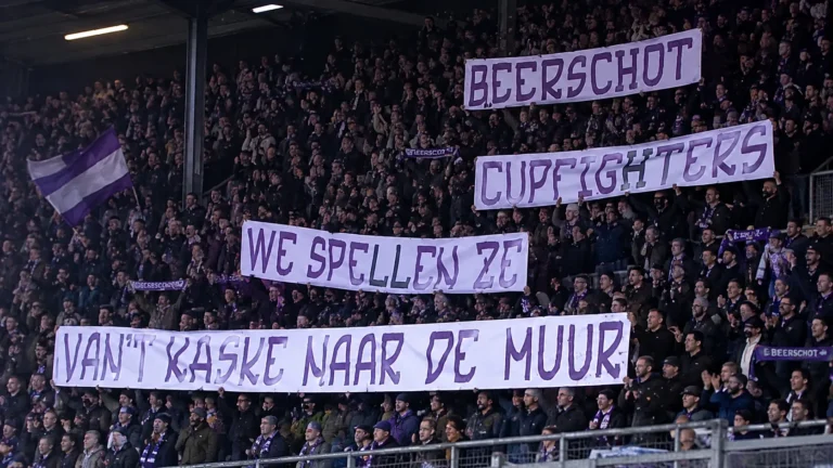 Beerschot-supporters op ’t Kiel met grote witte spandoeken en paarse belettering.