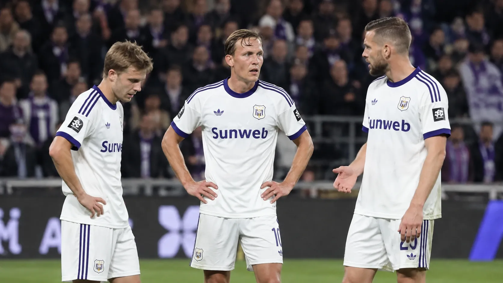 Drie Anderlecht-spelers in witte wedstrijdtenues tijdens een wedstrijd op het Kiel.