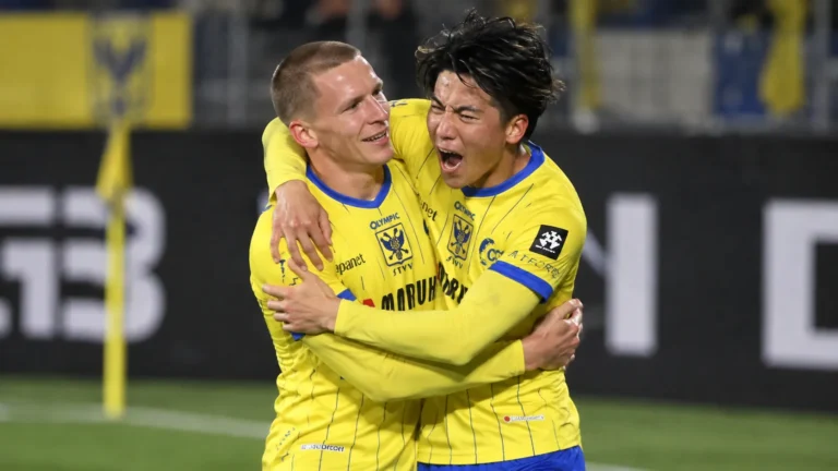 Twee STVV-spelers in gele tenues vieren samen tijdens een bekerwedstrijd.