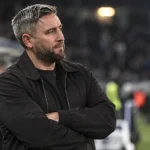 Lee Johnson kijkt na afloop van een wedstrijd vanaf de zijlijn het veld op.