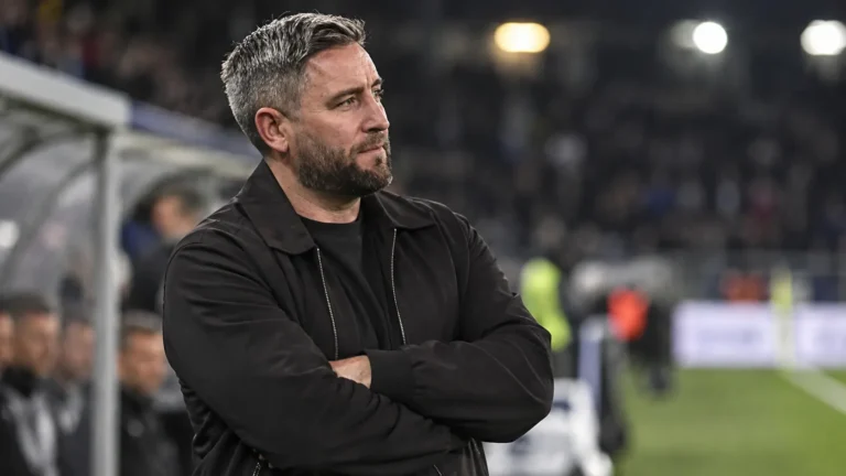 Lee Johnson kijkt na afloop van een wedstrijd vanaf de zijlijn het veld op.