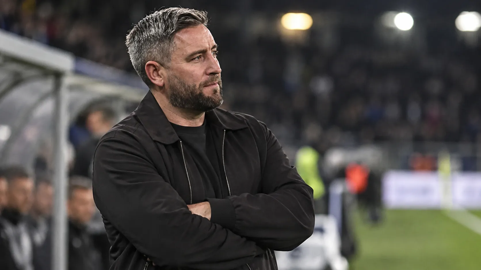 Lee Johnson kijkt na afloop van een wedstrijd vanaf de zijlijn het veld op.