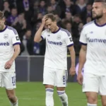 Anderlecht-spelers lopen teleurgesteld op het veld na een bekerwedstrijd.