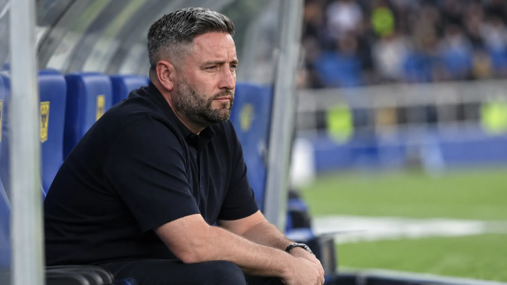 Lee Johnson zit teleurgesteld in de technische zone na een wedstrijd.