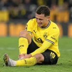 Konstantinos Karetsas van Borussia Dortmund houdt zijn enkel vast op het veld.