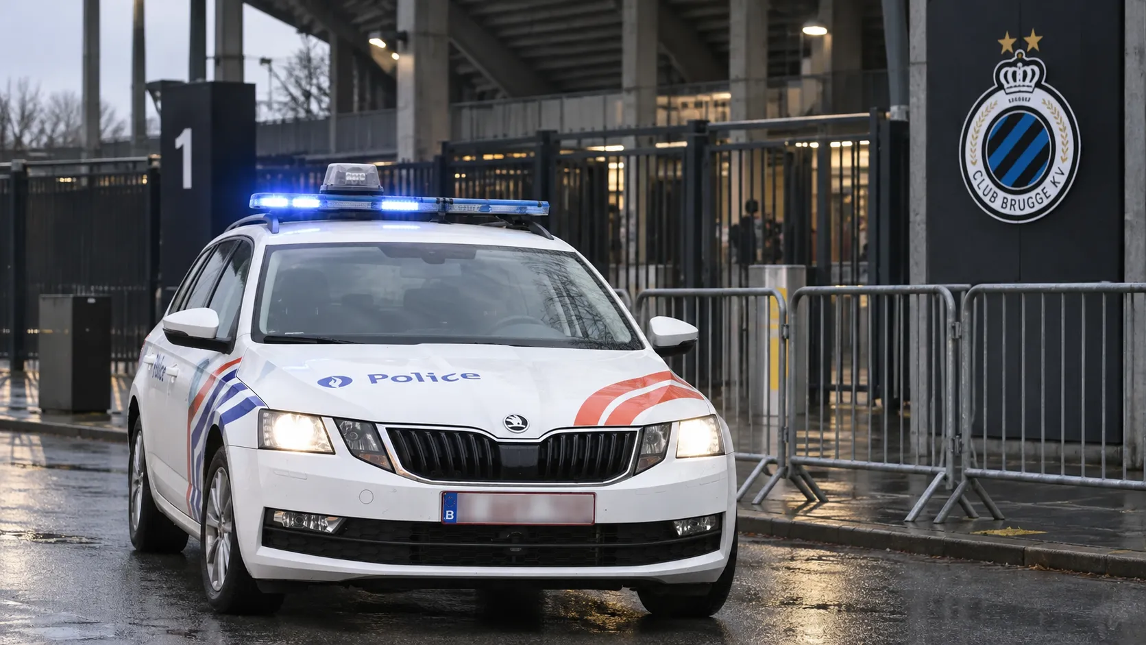 Politievoertuig aan de toegangszone van het Jan Breydelstadion met een Club Brugge-embleem op een vast stadionbord.
