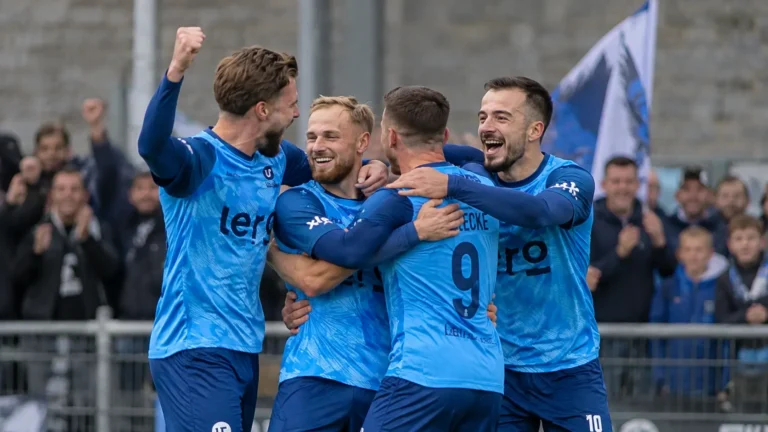 Spelers van Union Rochefort vieren samen langs het veld.