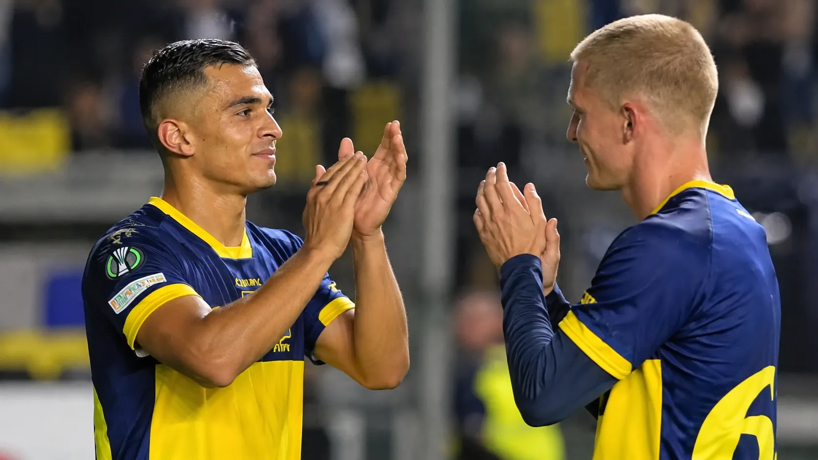 Twee voetballers applaudisseren elkaar na een wedstrijd.