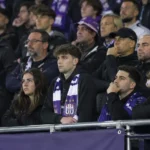 Een groep teleurgestelde Anderlecht-supporters op de tribune met een paars-witte sjaal.