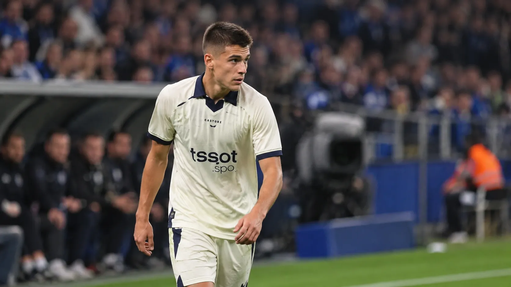 Nicolo Tresoldi van Club Brugge wandelt op het veld in een licht wedstrijdtenue.