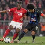Twee spelers vechten om de bal tijdens een Belgische bekerwedstrijd.