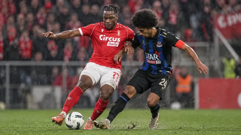 Twee spelers vechten om de bal tijdens een Belgische bekerwedstrijd.