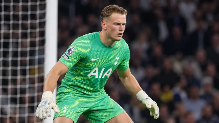 Een Tottenham-doelman in groen tenue reageert tijdens een wedstrijdmoment.