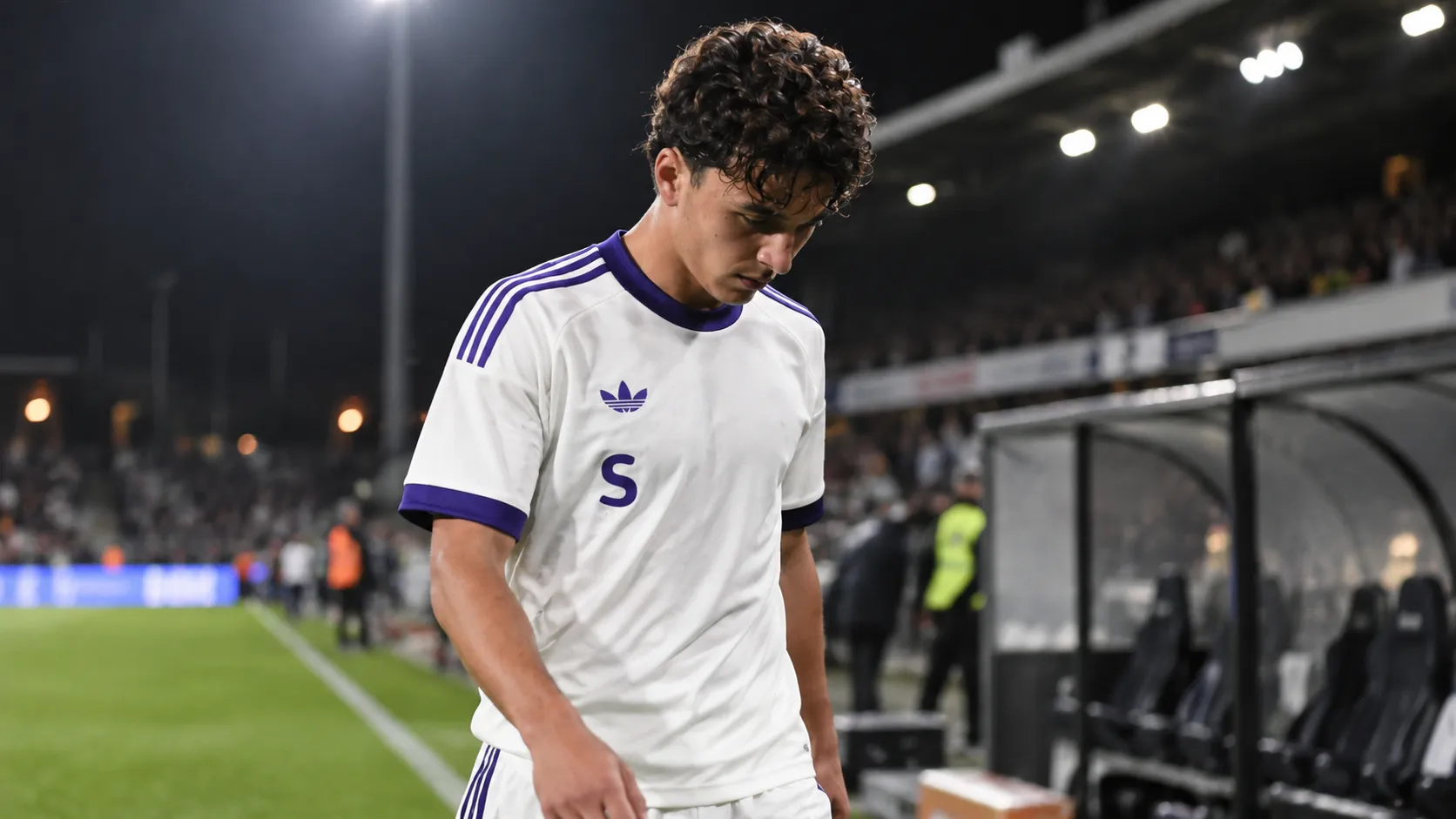 Ali Maamar loopt na een avondwedstrijd over het veld in zijn wedstrijdshirt.