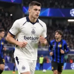 Nicolo Tresoldi warmt op in zijn witte Club Brugge-tenue voor een Europese avondwedstrijd.