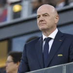 Gianni Infantino in donker pak met een FIFA-badge tijdens een voetbalevenement.