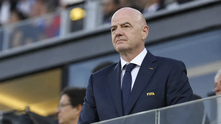 Gianni Infantino in donker pak met een FIFA-badge tijdens een voetbalevenement.