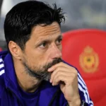 Een staflid van Anderlecht zit in de dug-out tijdens een wedstrijd.
