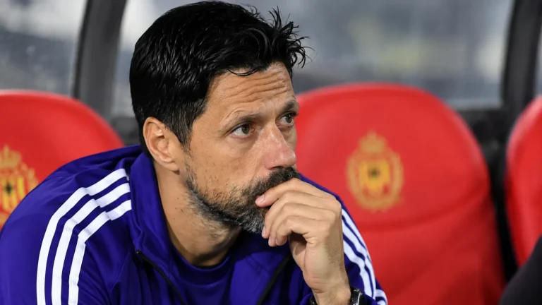 Een staflid van Anderlecht zit in de dug-out tijdens een wedstrijd.