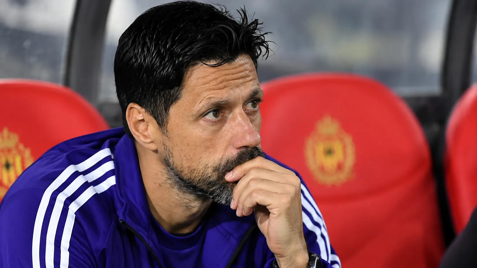 Een staflid van Anderlecht zit in de dug-out tijdens een wedstrijd.